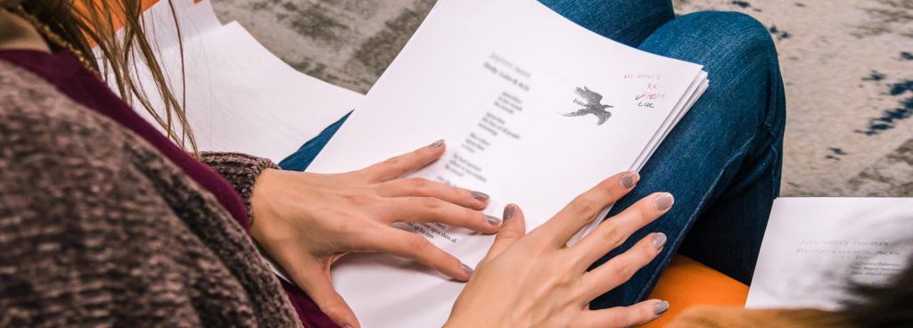 Hands holding poetry manuscript