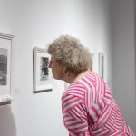 person looking at framed art on wall