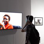 person with headphones on watching video on a tv monitor