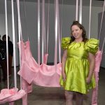 person in front of pink sculpture in gallery