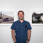 person in front of framed photos in gallery