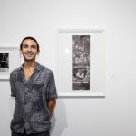 person in front of framed art in gallery