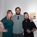 three people posing for the camera in the gallery