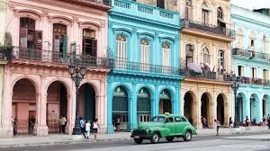 Vintage car in front of colorful buldings in La Habana