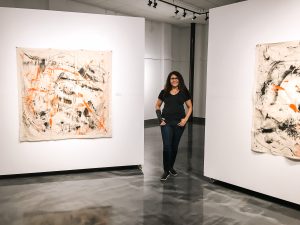Marlenys Rojas-Reid in front of her artworks
