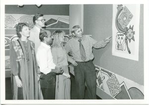 “Courtesy of UCF Special Collection & University Archives.” Professor Gaudnek showing his artwork for a group of people including Professor Chavda.