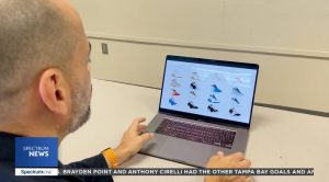 Graphic design instructor looks at shoe designs on a laptop