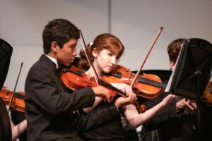 Two students playing violin.