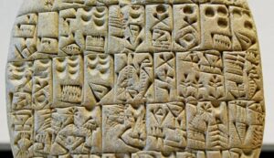 Close-up of an ancient clay tablet inscribed with cuneiform writing.