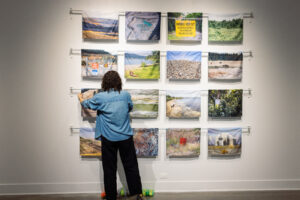 Artist Amanda Leigh Evans installs a grid of landscape photographs in the UCF Art Gallery.