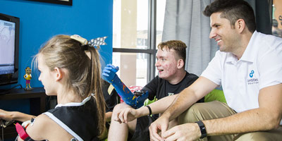 Professor Matt Dombrowski and two teens with custom prosthetics
