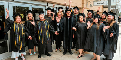 Themed experience students with faculty in graduation attire