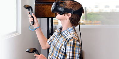 Young person uses VR headset and controllers
