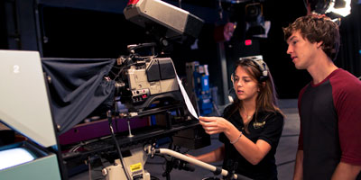 Two students operate a large camera onset