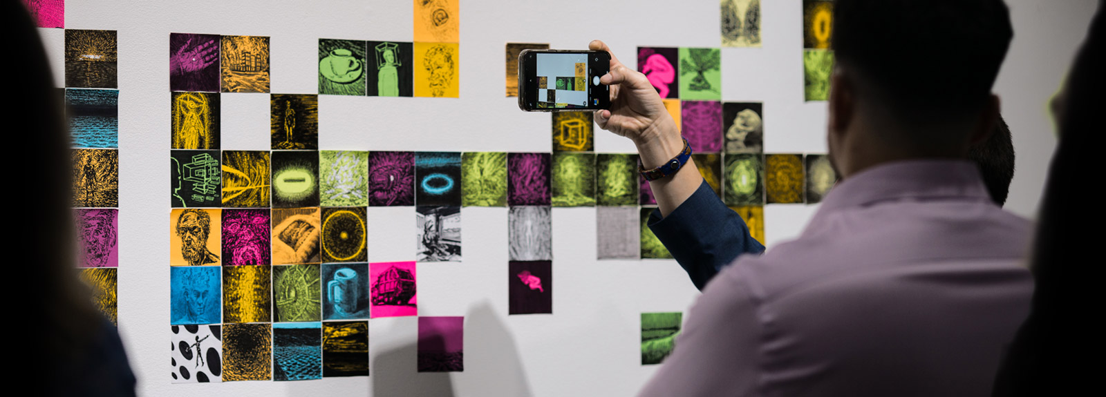 Visitors view and photograph an art installation in the gallery