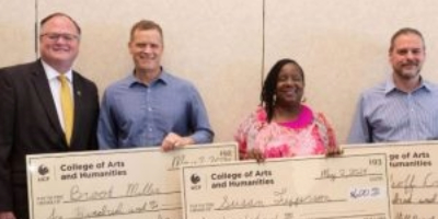 Photo of CAH Dean and staff awards recipients holding large checks