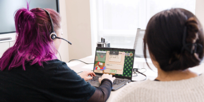 Professor and student working on a computer