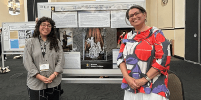 Student and faculty mentor pose with research poster