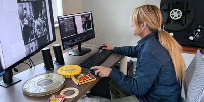 Student uses computer workstation to scan old film