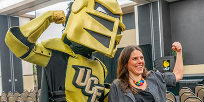 Knightro flexes with faculty member