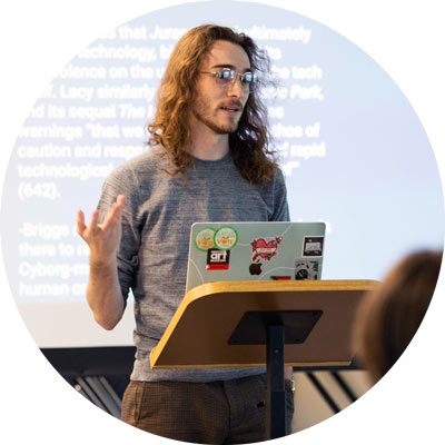 Student with laptop presents in front of projection