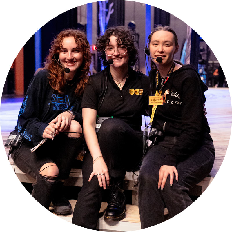 Three stage managers pose together