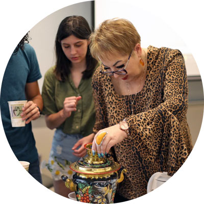 Students with Russian professor Alla Kourova using ornate tea jar
