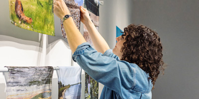 Person mounts art on gallery wall