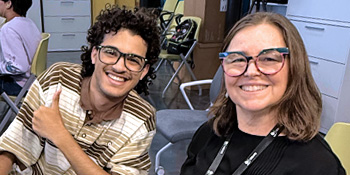 Student and faculty member smile
