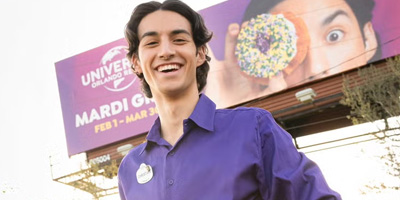 Christian Spencer poses in front of Universal Orlando billboard