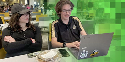 Students behind laptop with green pixel overlay