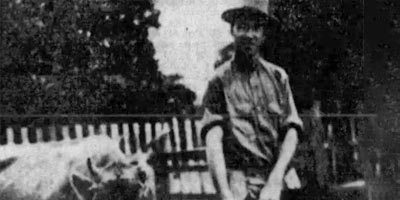 Old, black-and-white photo of a man with a dairy cow