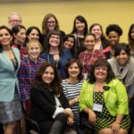 A larger group of women pose together at the 2016 International Women’s Issues Conference