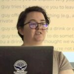 Student researcher presents behind laptop
