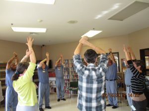 Students and facilitators stretching in a performing arts class