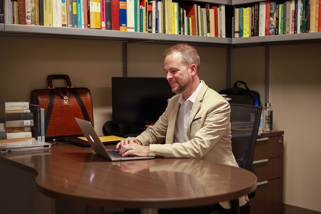 Dr. Tyler Fisher at his desk in Modern Languages and Literatures