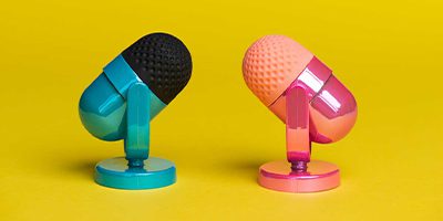 Two different colored microphones sitting side-by-side