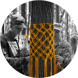 Army ROTC students decorate a tree with yellow tassels