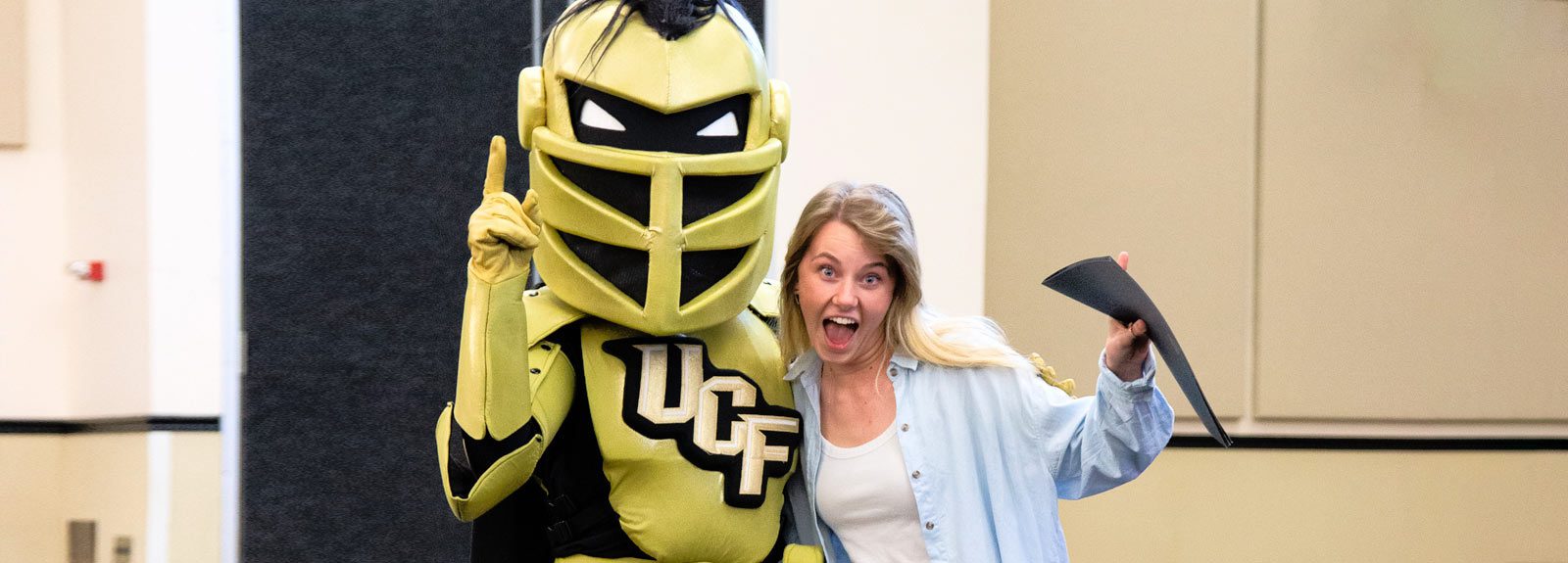 Student writer poses with Knightro mascot