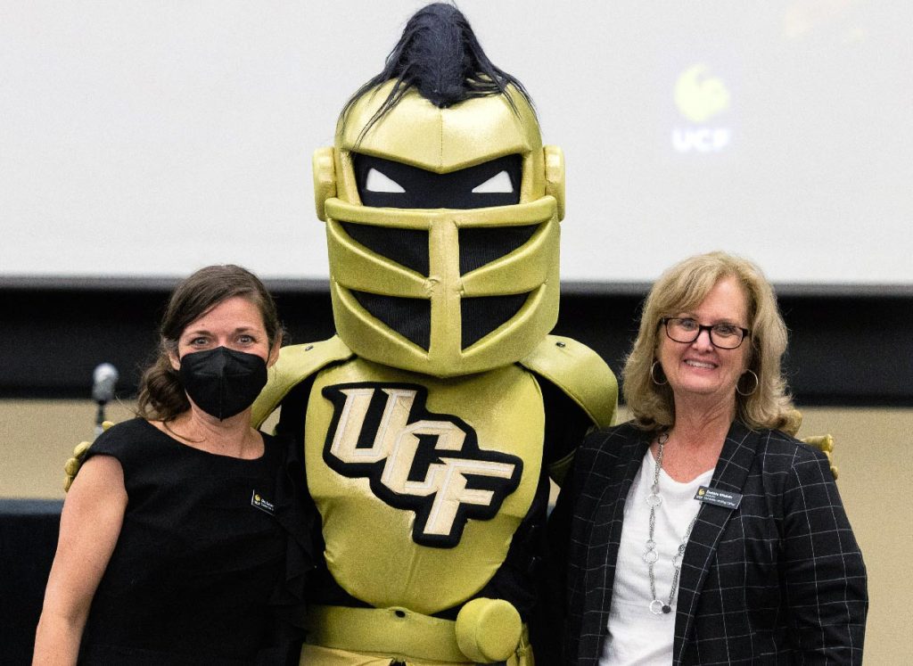 Knightro mascot poses with two writing faculty members