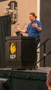 Smiling student interacts with event visitors